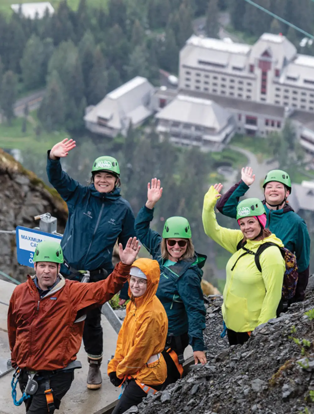 guests braving the Veilbreaker Skybridges wave at the camera during a short rest, the Alyeska resort is visible the background