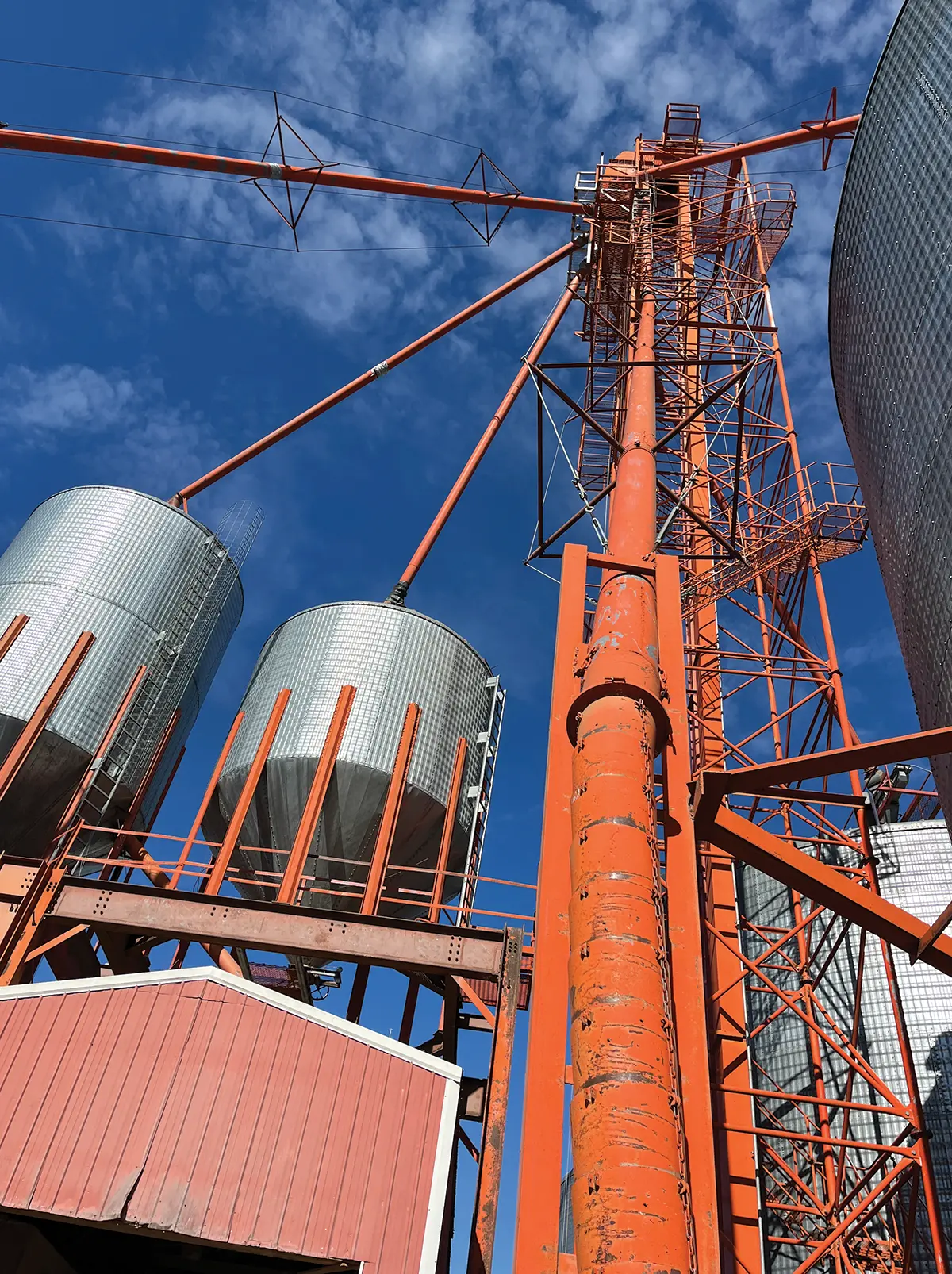 Portrait photograph of co-op galvanized bins all linked up by red metal steel rusty structure shapes