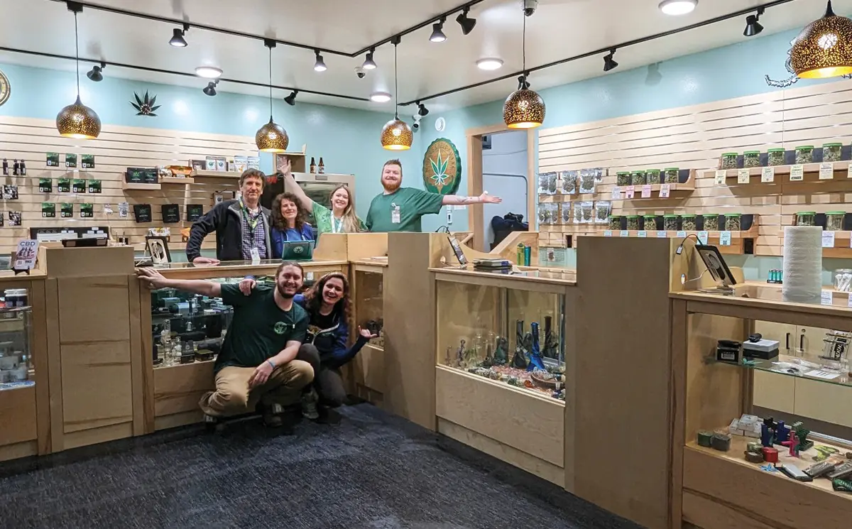 interior view of Nature’s Releaf's new larger retail space, six employees stand smiling and grouped at the corner of the retail display counter