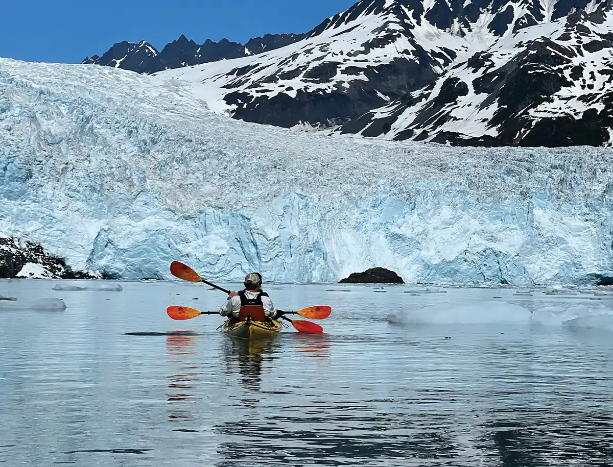 wide view of two people kayaking in the wintry Resurrection Bay on a clear bright day