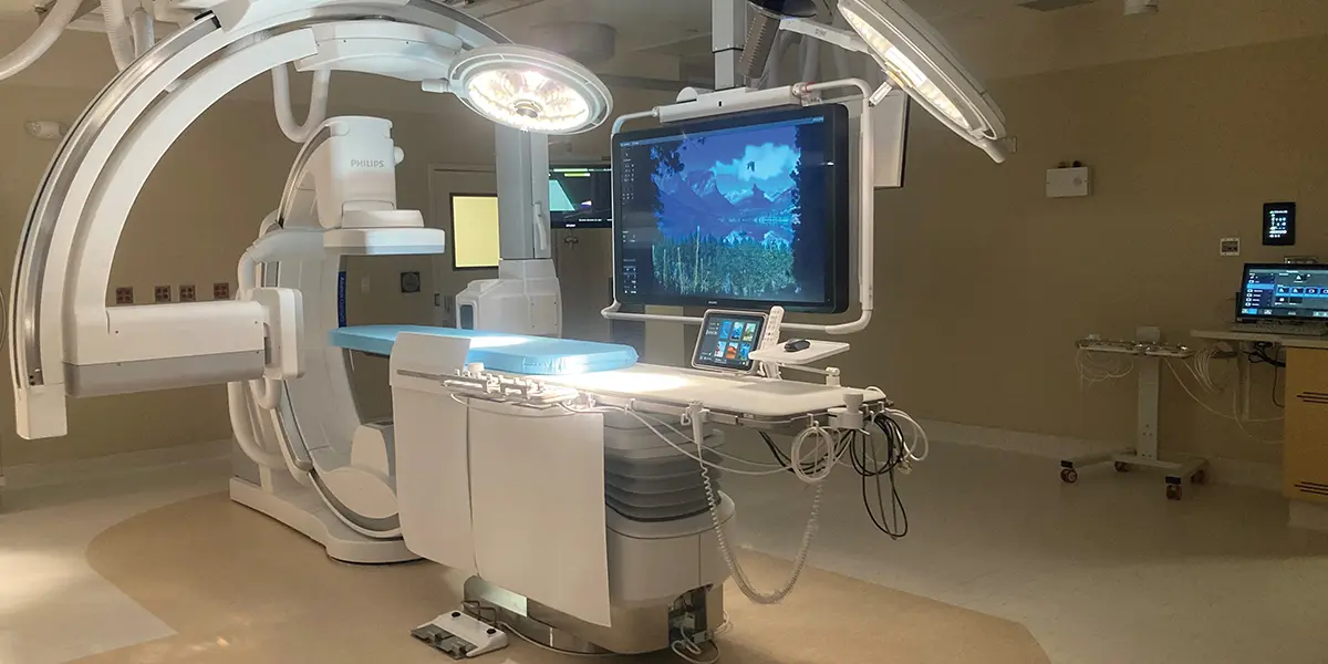 wide view of a large X-ray/imaging room featuring a large Philips machine with multiple touch screen interfaces