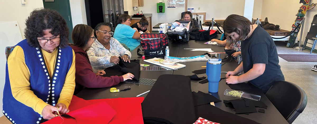 group of women working with different pieces of fabric at table together 