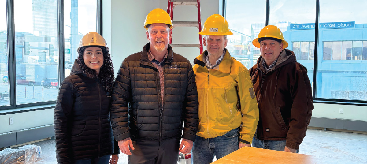 group photo of Amanda Doney, Mike Dennis, Sheldon Fisher, and Mark Begich wearing hardhats
