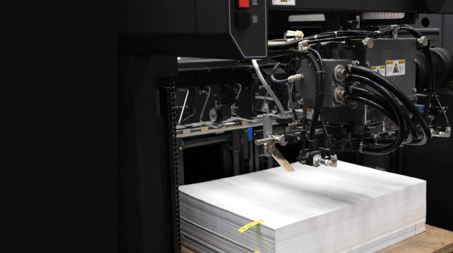 A close-up of a printing press feeding paper