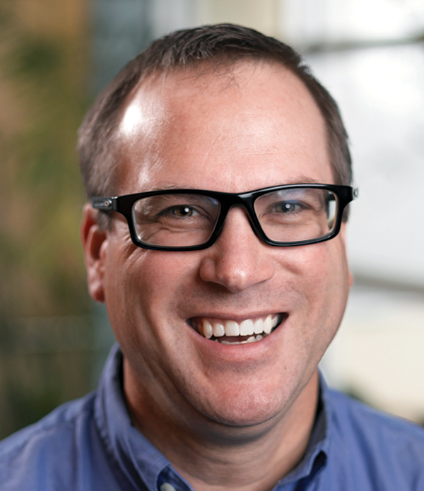 Portrait orientation close-up headshot photograph of Ben Momblow smiling