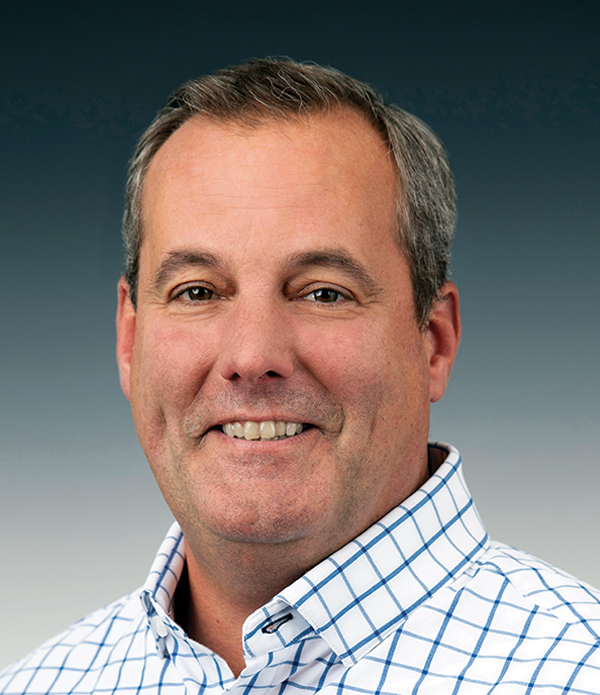 Portrait orientation close-up headshot photograph of Jason Reeves smiling