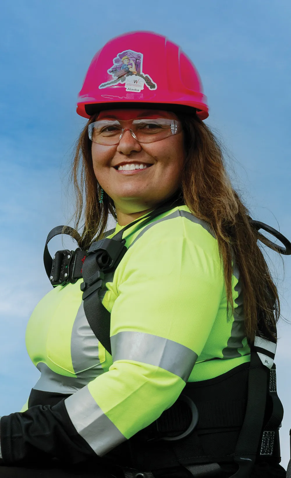 portrait photo of a woman construction worker smiling while wearing her safety clothing, gear and hardhat