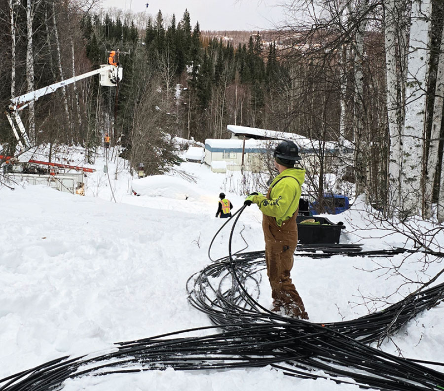 GCI workers installing fiber while supervising worker on crane