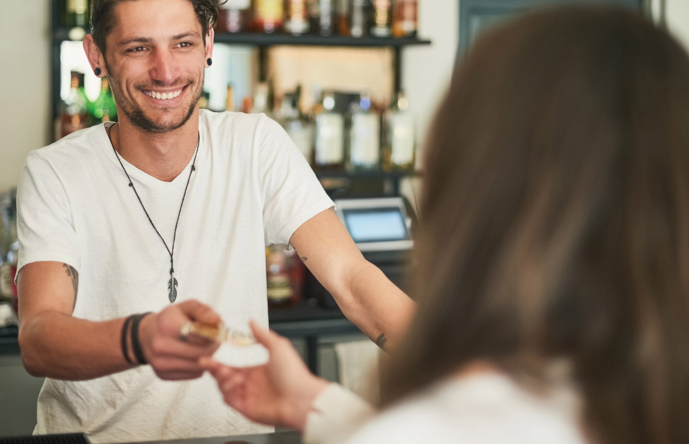 man smiling while handing a card back to another person