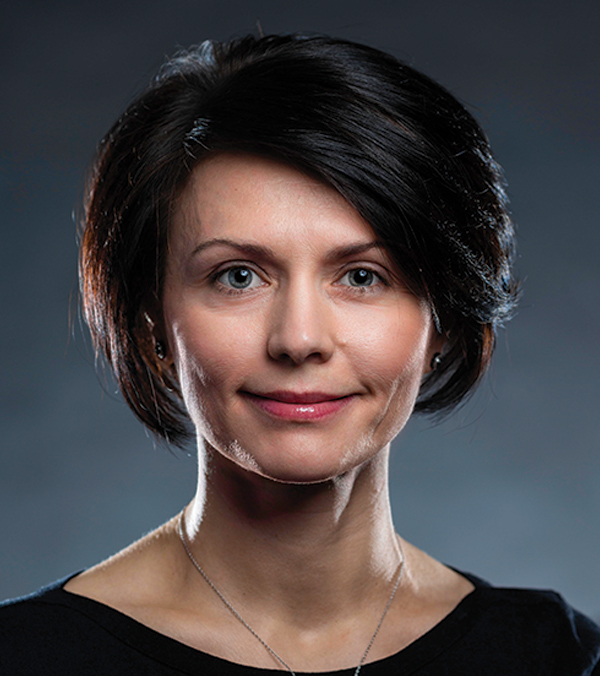 Portrait orientation close-up headshot picture view of Corina Ovod-Everett grinning