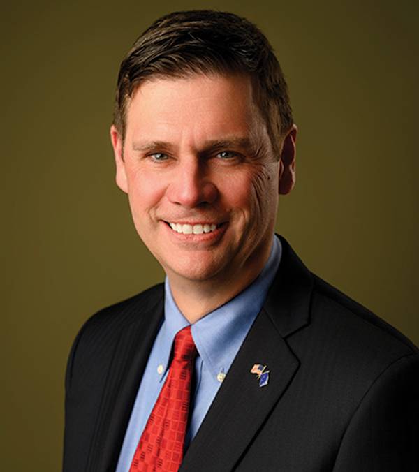 Portrait orientation close-up headshot picture view of Larry B. Monsma smiling