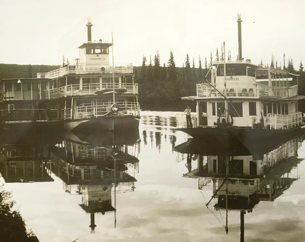 sepia-colored photo of three steamboats resting idly in the water