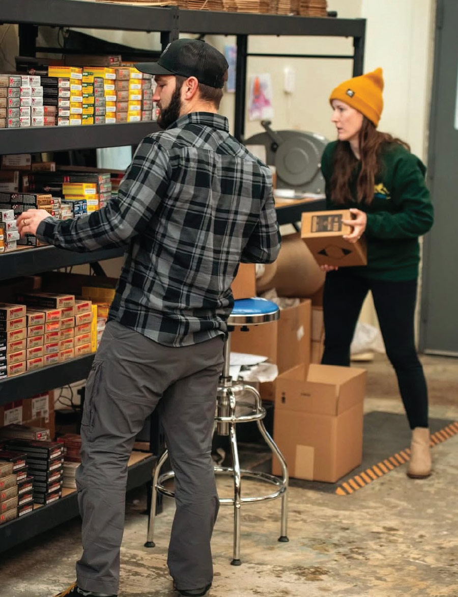 man and woman restocking ammunition shelves