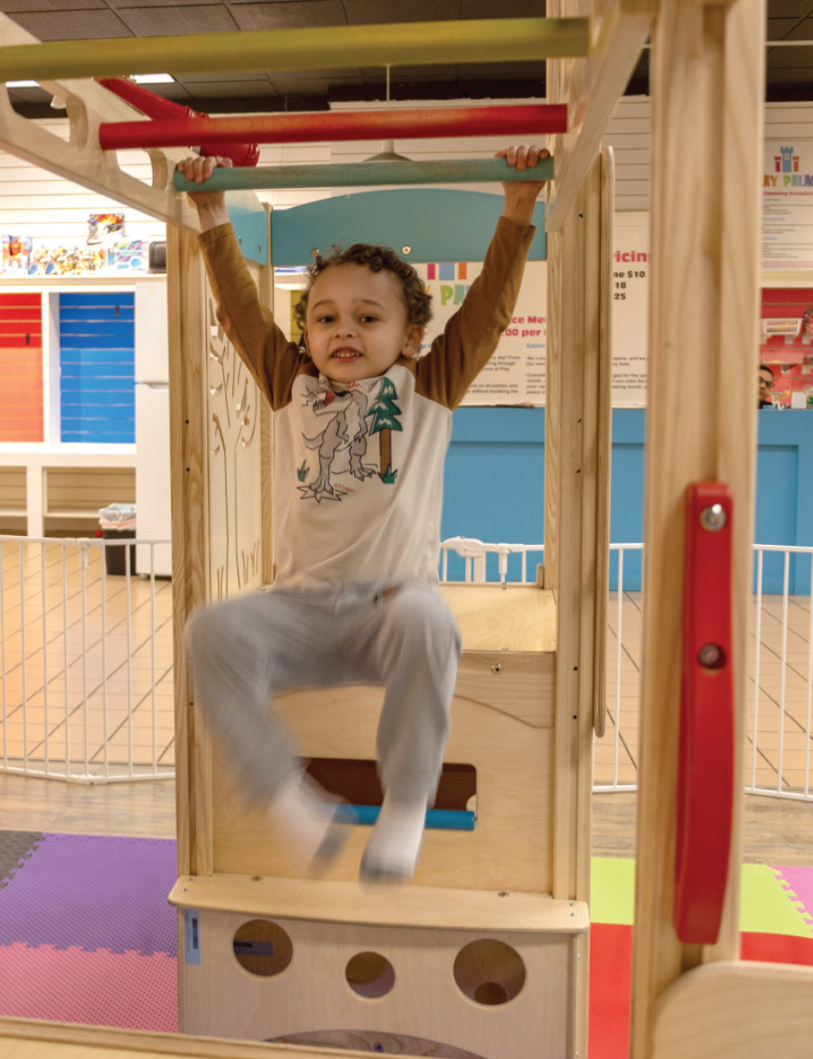 child on monkey bars at Play Palace