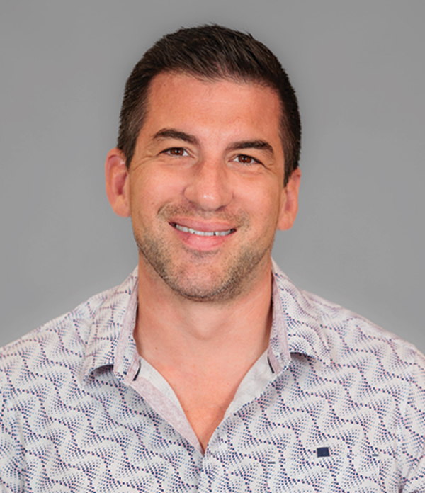 Portrait orientation photograph headshot of Travis Malin smiling
