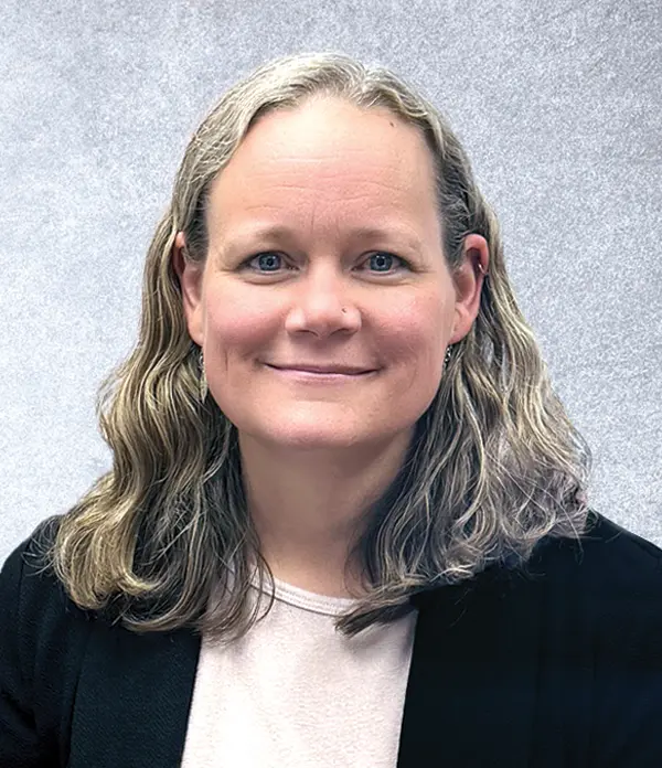 Portrait orientation photograph close-up headshot view of Sarah Moyers grinning