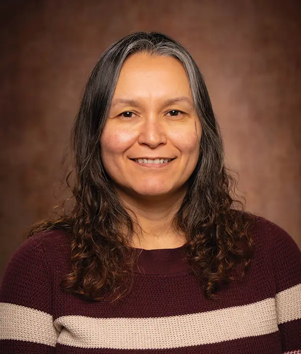 Portrait orientation photograph close-up headshot view of Jacque Mills smiling