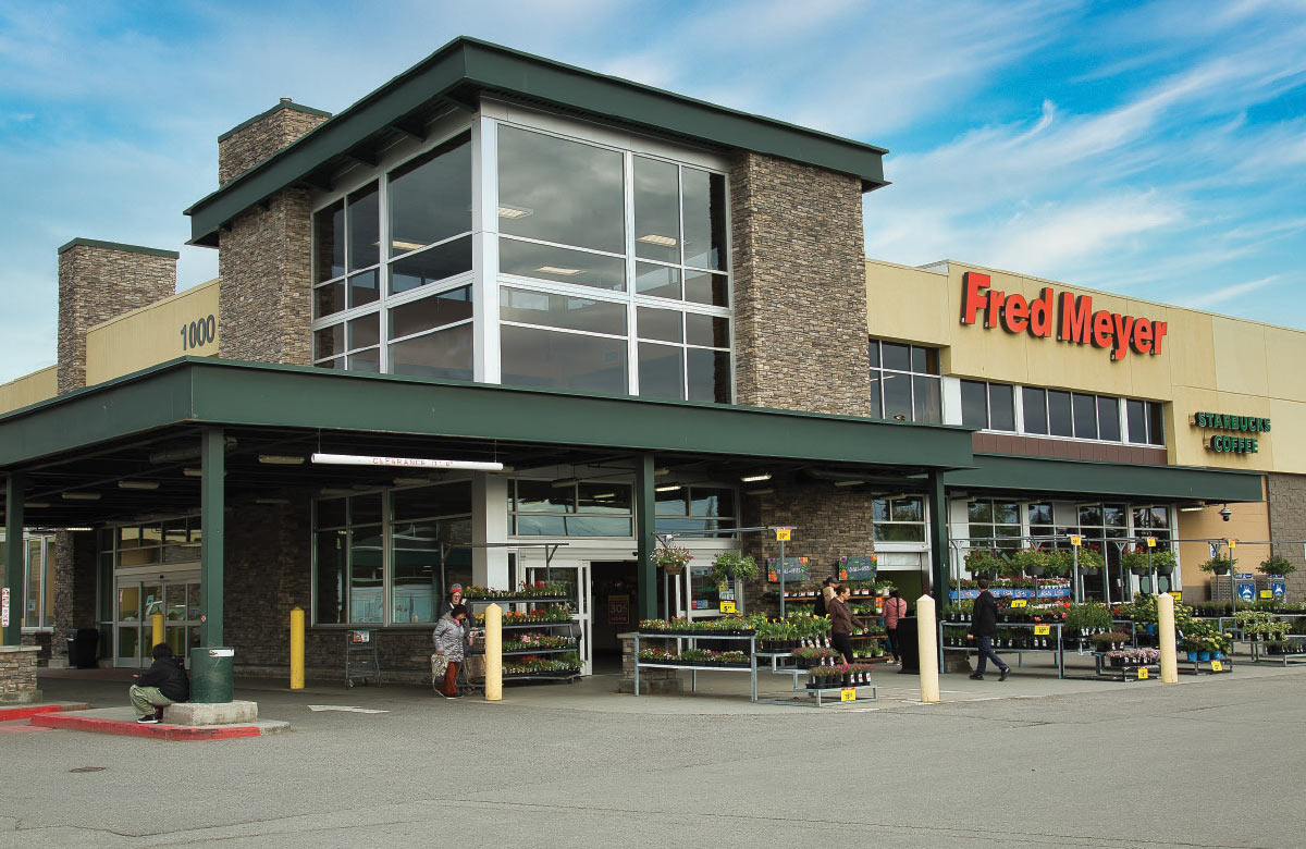 A low-angle exterior shot of a Fred Meyer grocery store on a sunny day.