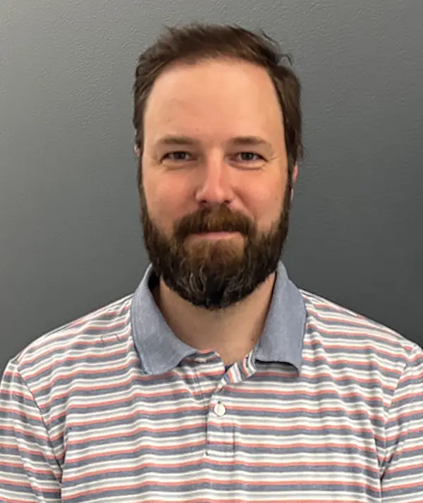 Portrait orientation photograph close-up headshot view of Adam Dalton grinning