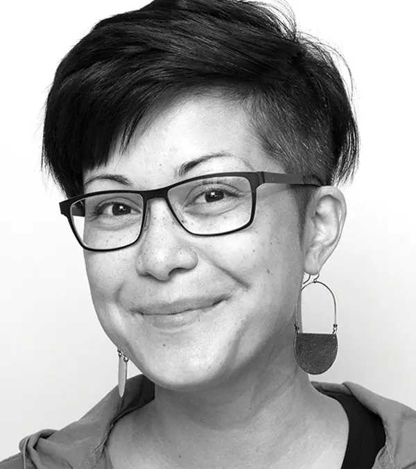 Portrait orientation black and white photograph headshot close-up of Asia Bauzon grinning