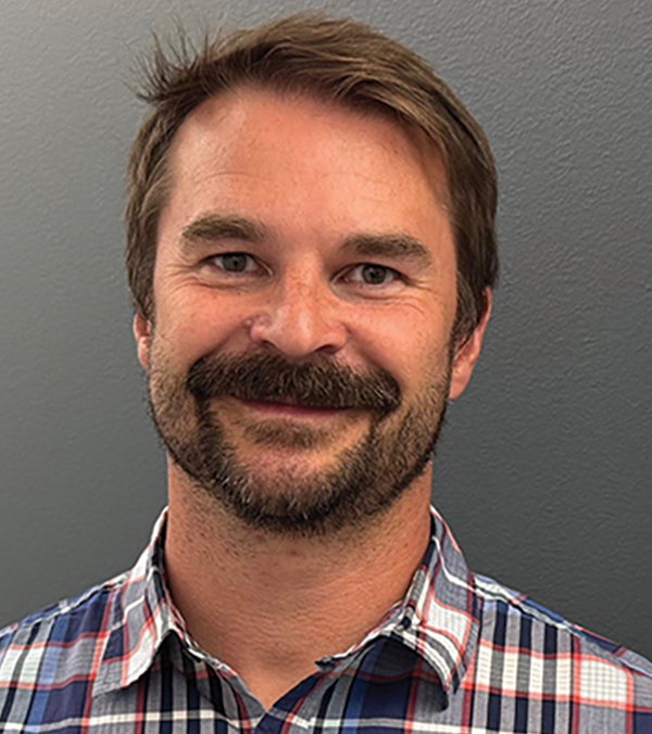 Portrait orientation photograph headshot close-up of Jason Johnston grinning