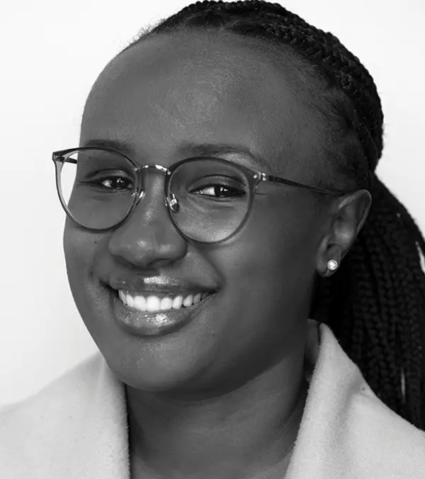 Portrait orientation black and white photograph headshot close-up of Mercy Nyaga smiling