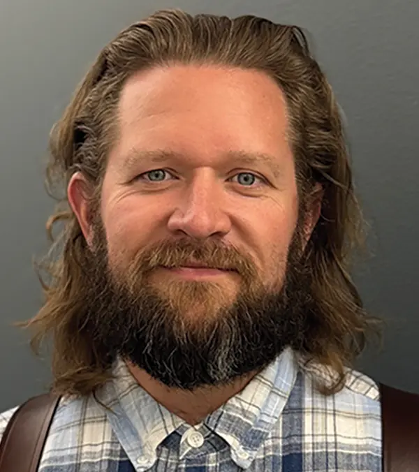 Portrait orientation photograph headshot close-up of Trevor Copple grinning