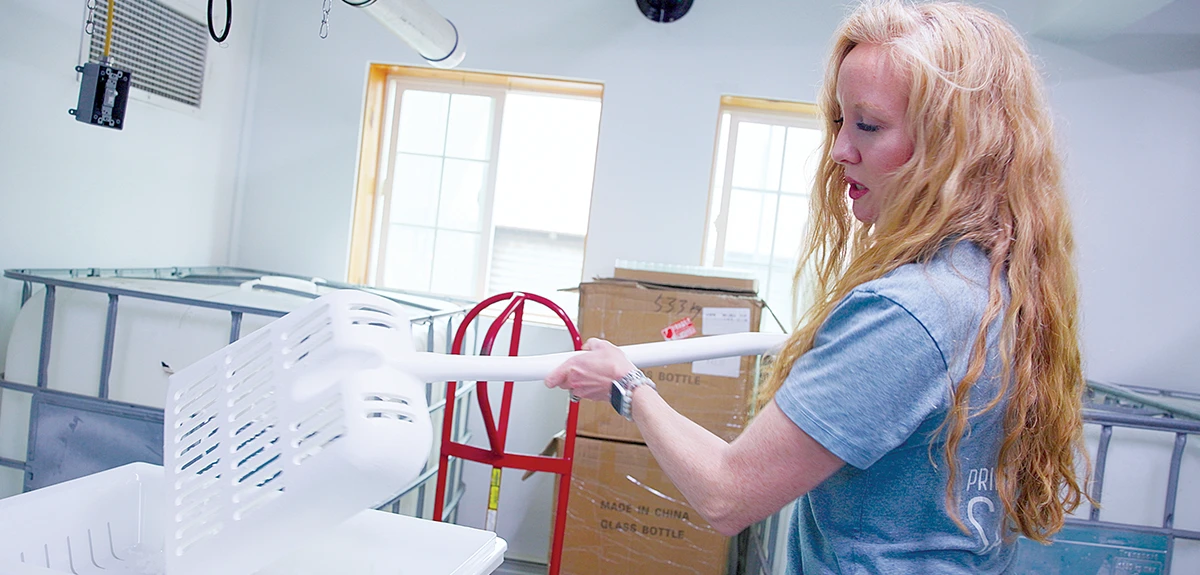 a woman shovels salt in a well lit storeroom