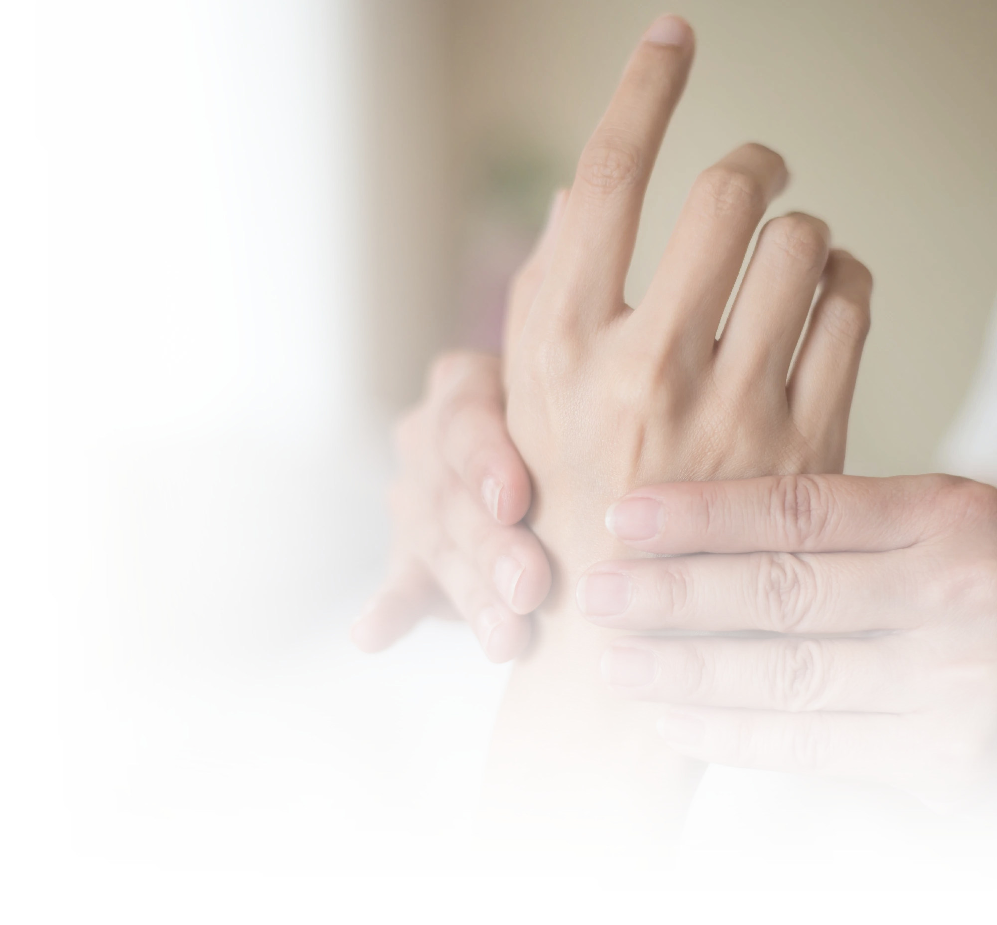 Close-up photo of two hands gently performing a therapeutic massage or assessment on the wrist and back of a third hand.