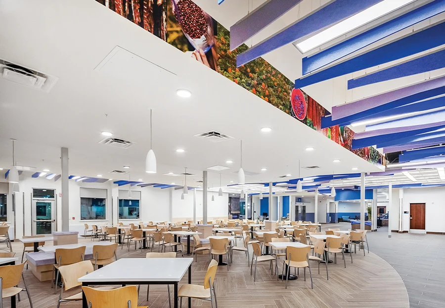 Architectural rendering of a modern hospital patient care area featuring semi-private bays with wood-slat ceilings, comfortable reclining chairs, and medical staff attending to patients in a bright, open environment