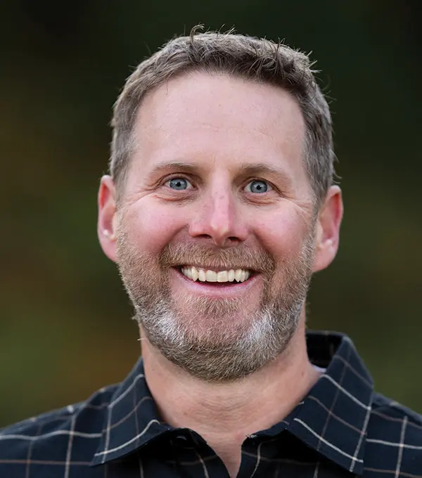 Headshot photograph of Jesse Kleinbach smiling