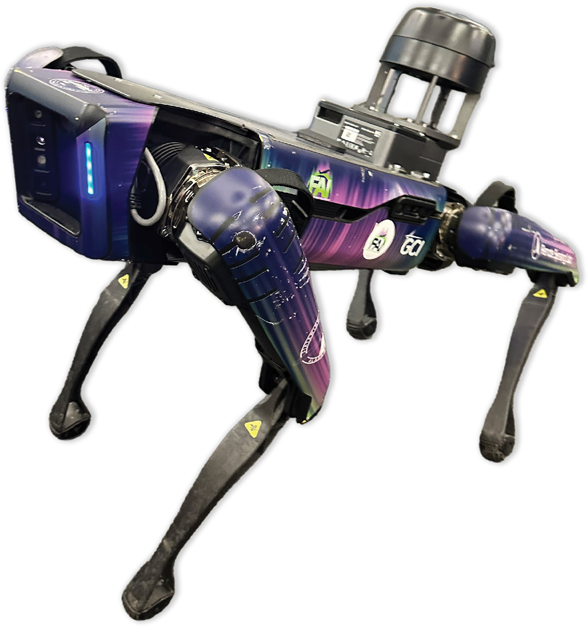 A quadruped robot dog featuring a purple and blue aurora borealis patterned skin with GCI and FAI logos. It has specialized sensors mounted on its back and is shown against a white background.