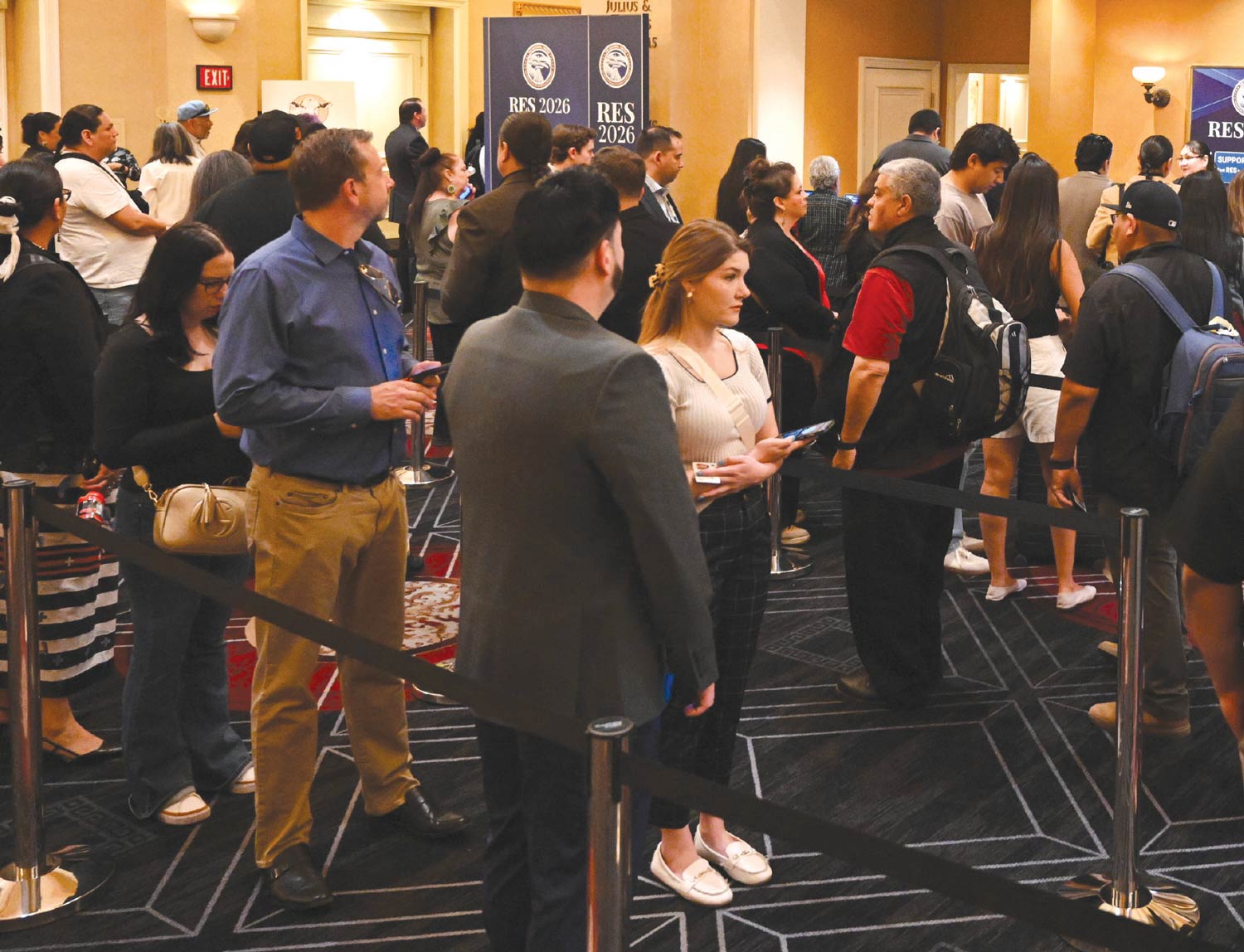 Attendees wait in a long queue at a registration area for the RES 2026 conference in a carpeted hotel lobby.