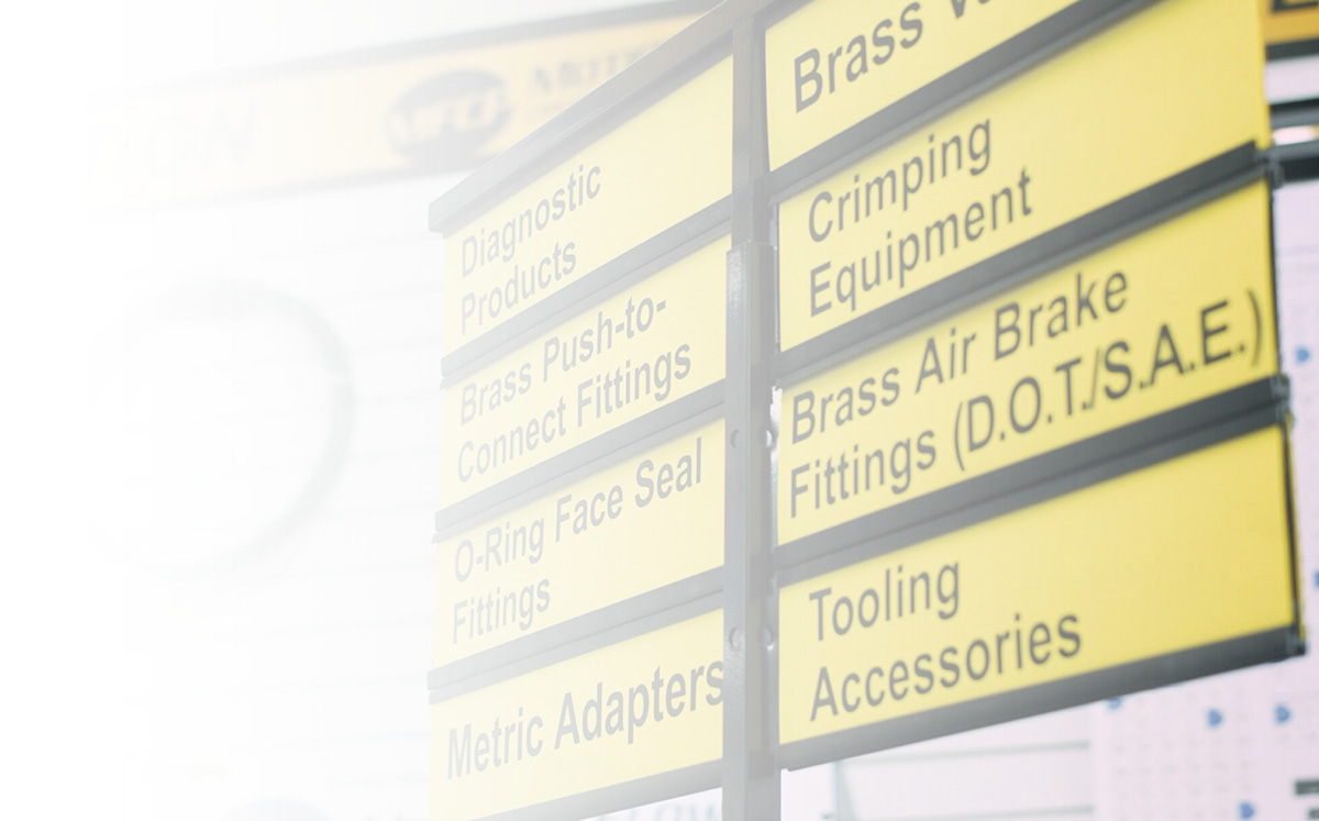 Yellow signs listing industrial products like diagnostic tools, crimping equipment, and brass fittings.