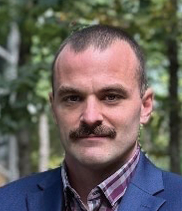 Headshot photograph of Kris Squires grinning
