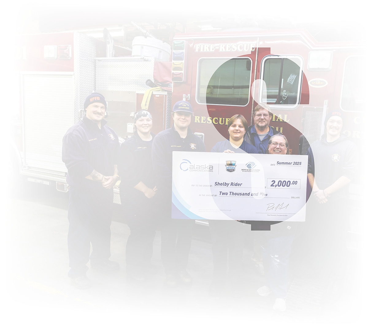 First responders holding a large donation check for $2,000 in front of a fire engine.