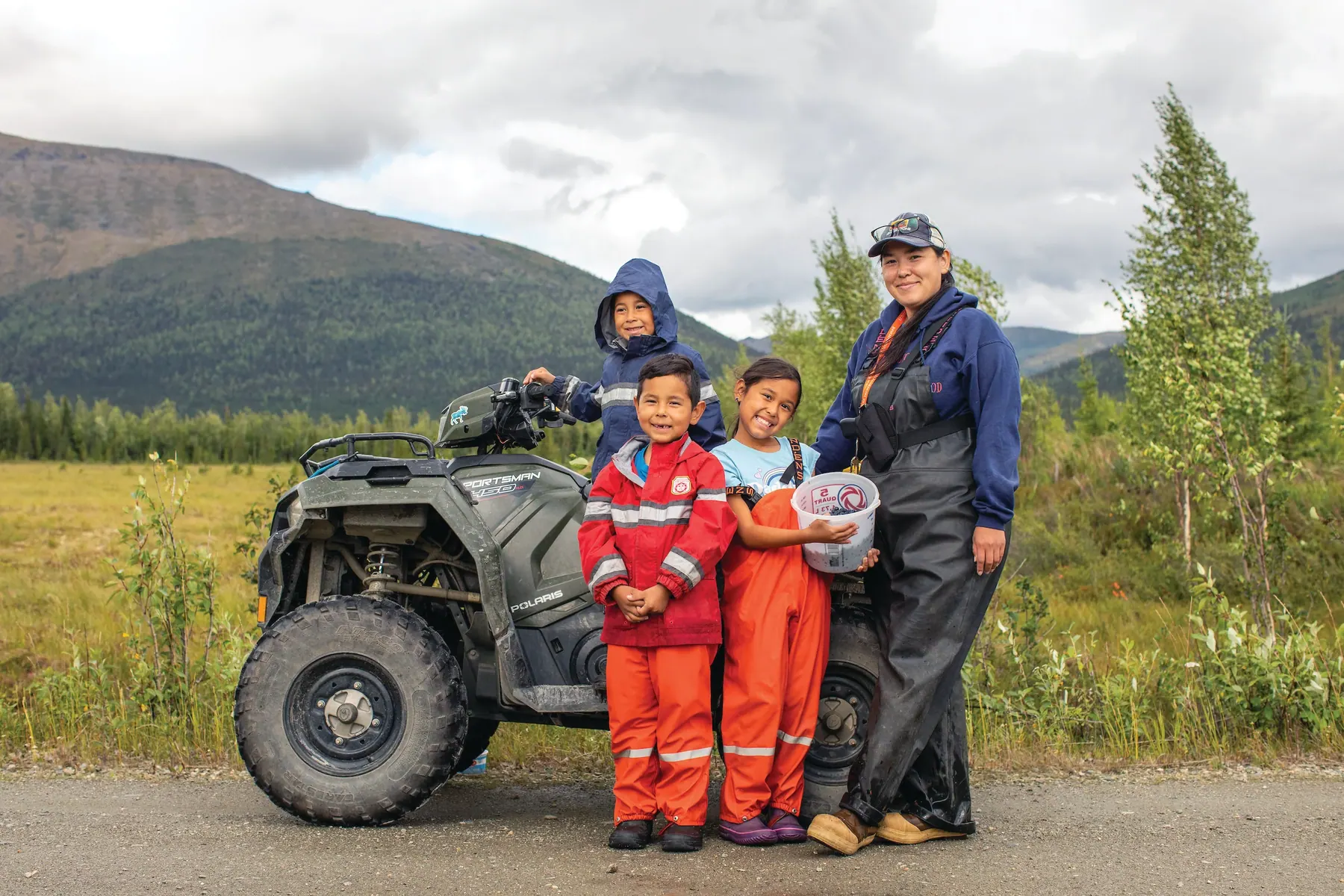 NANA shareholder Jaelyn Natiġvik Kuutuuq Cleveland and her children, Chasity Paaniikaaluk Qalhaq Williams, Alvin Kituq Williams, and Kenai Aaquk Kayuqtauq Williams, enjoy a day picking tundra blueberries together near Kobuk, in the NANA region.